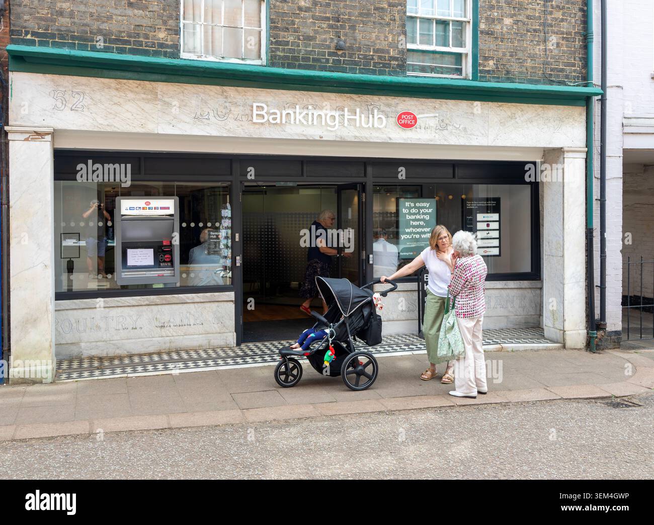 Tow Women discutant dans la rue devant Banking Hub, The Thoroughfare, Woodbridge, Suffolk, Angleterre, ROYAUME-UNI Banque D'Images