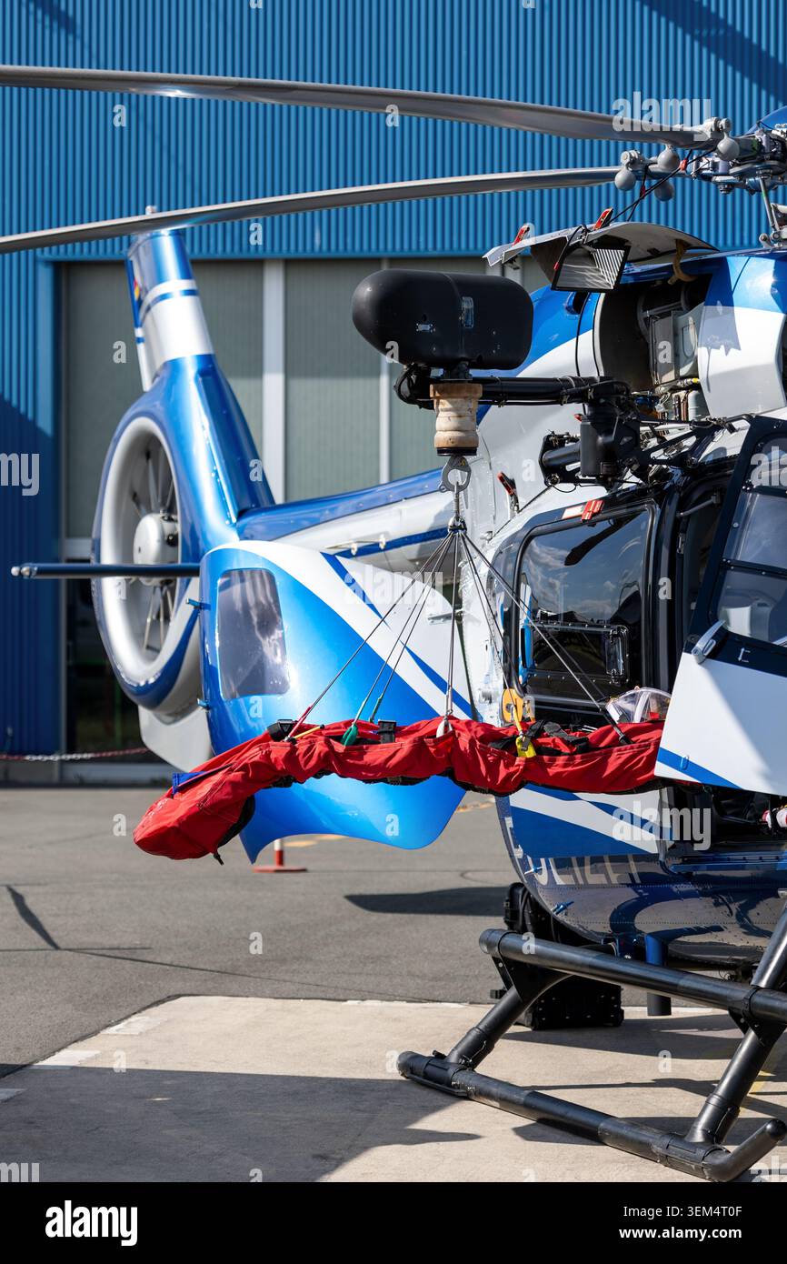 Hélicoptère de sauvetage se tient prêt à évacuer brancard suspendu à porte de cabine ouverte aérodrome. Équipement spécialisé capacité d'intervention d'urgence médicale Banque D'Images