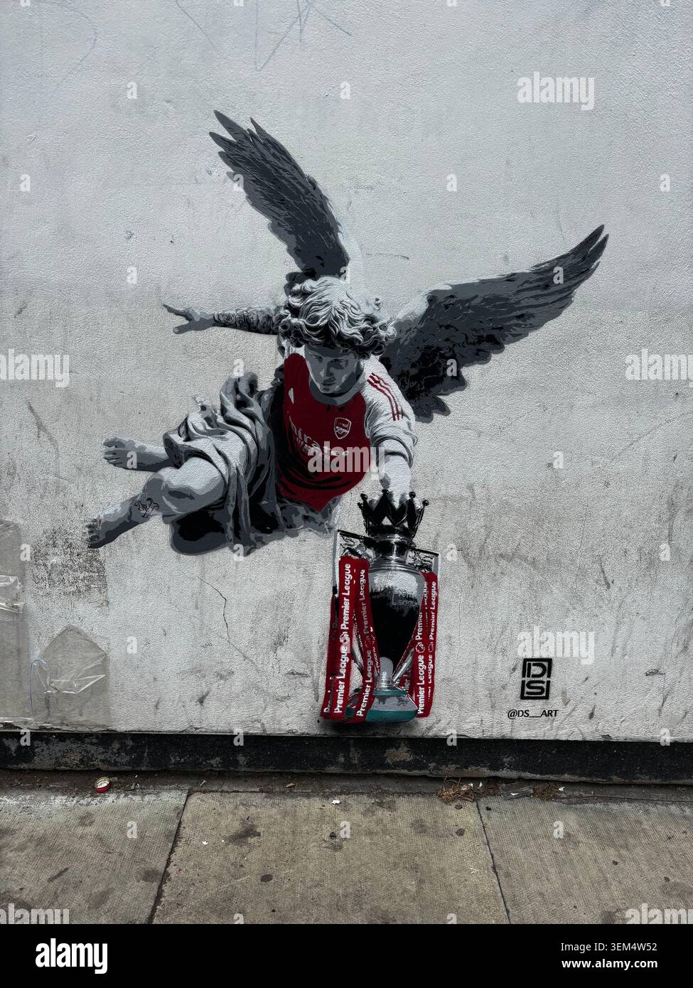 Peinture murale Street art représentant un ange dans un maillot de football Emirates portant le trophée de la premier League sur un mur à Islington, au nord de Londres, Angleterre, Royaume-Uni. - Image de stock capturée avec un smartphone