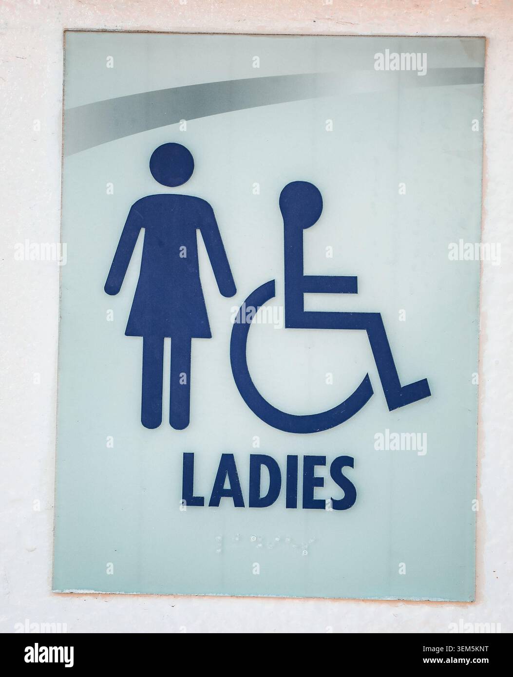 Signe de toilettes pour dames avec icônes accessibles aux femmes et aux fauteuils roulants sur le mur blanc Banque D'Images