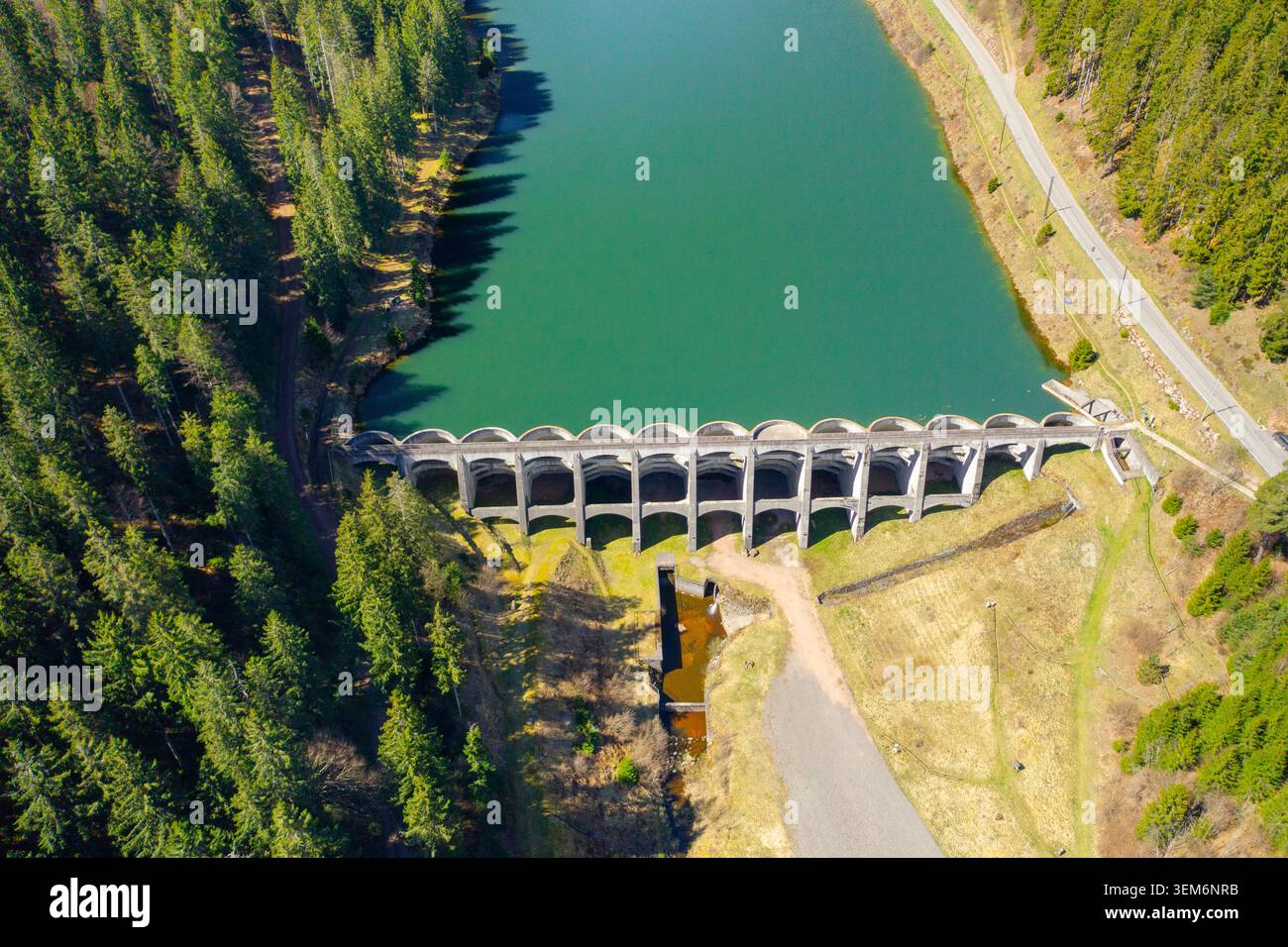 Photographie par drone descendante d'un barrage historique en béton tenant un réservoir de montagne entouré de forêt. Ressources en eau et concept de génie civil Banque D'Images