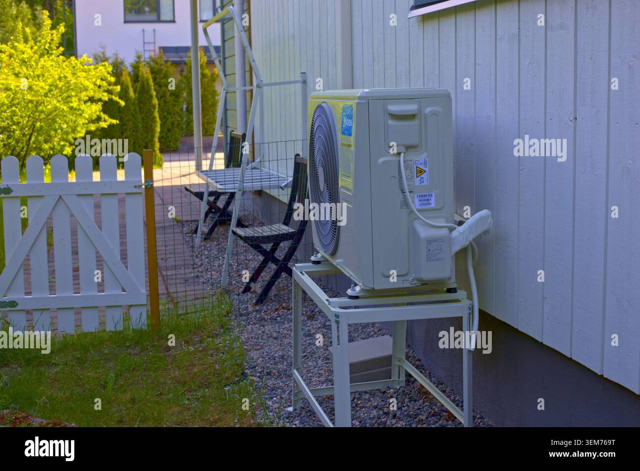 Turku, Finlande - 2 juin 2026 - Une pompe à chaleur à source d'air extérieur de marque Midea est montée sur un support métallique à côté du mur en bois d'une résidence Banque D'Images