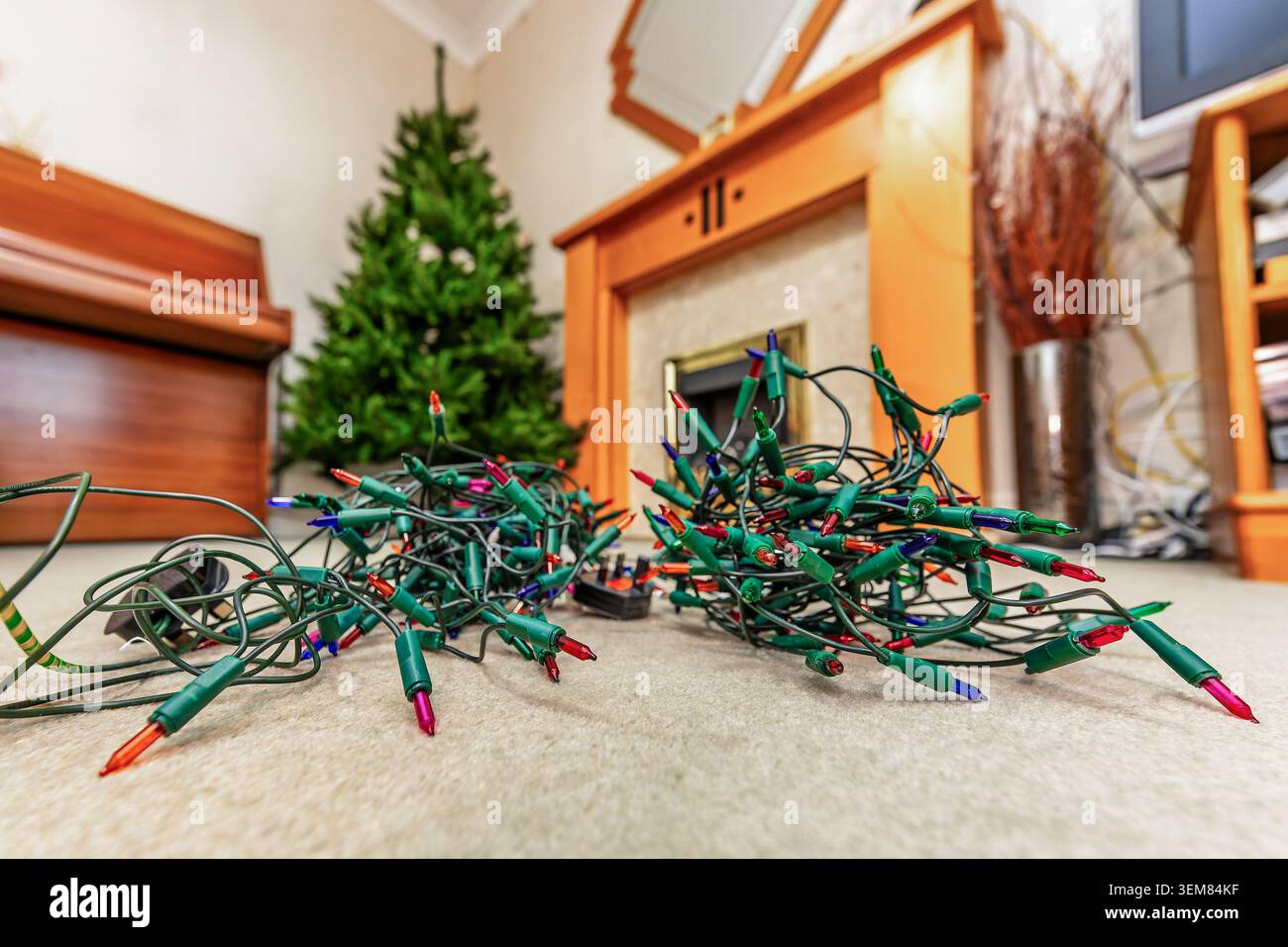 Arbre de Noël artificiel debout dans un salon avec des lumières de fée prêt à décorer pendant la saison des fêtes Banque D'Images