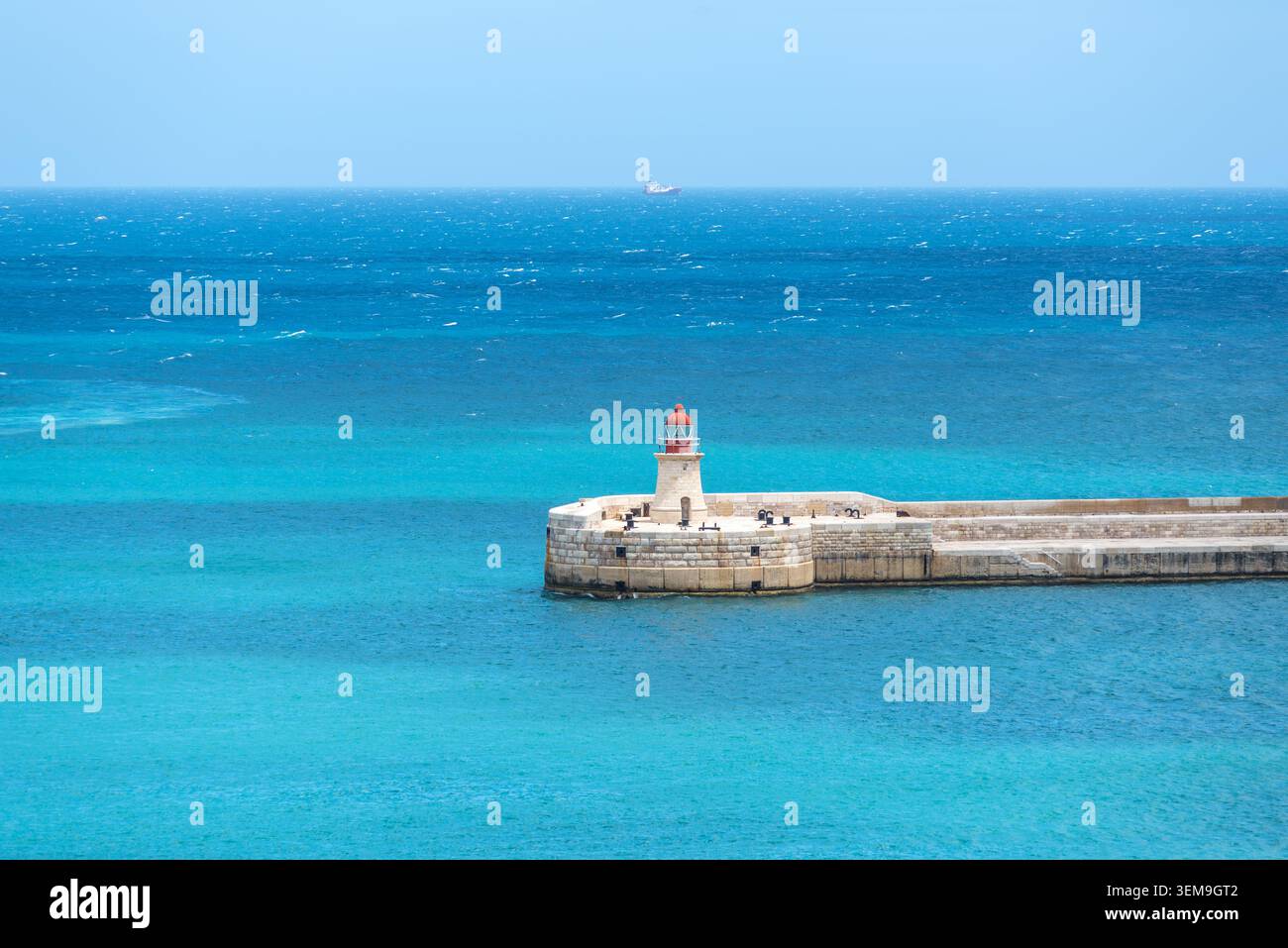 Vue sur l'entrée du port et le vieux brise-lames médiéval Ricasoli East avec son phare, debout au-dessus des eaux turquoises de la Méditerranée à la GA Banque D'Images