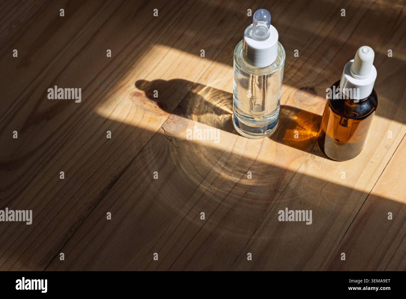 Deux flacons compte-gouttes en verre projetant de longues ombres Banque D'Images
