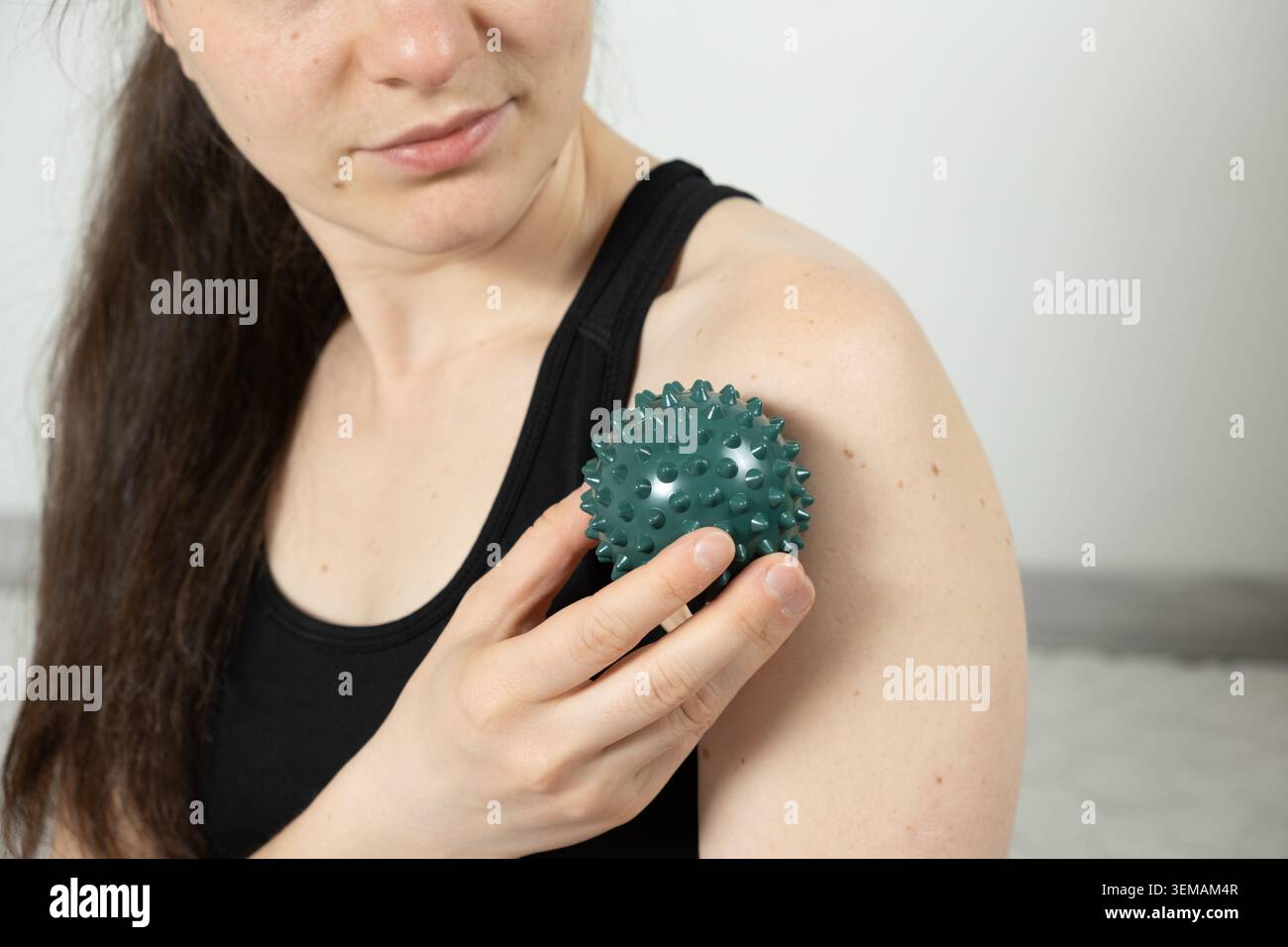Femme utilisant la boule de massage pour le soulagement de la douleur de l'épaule Banque D'Images