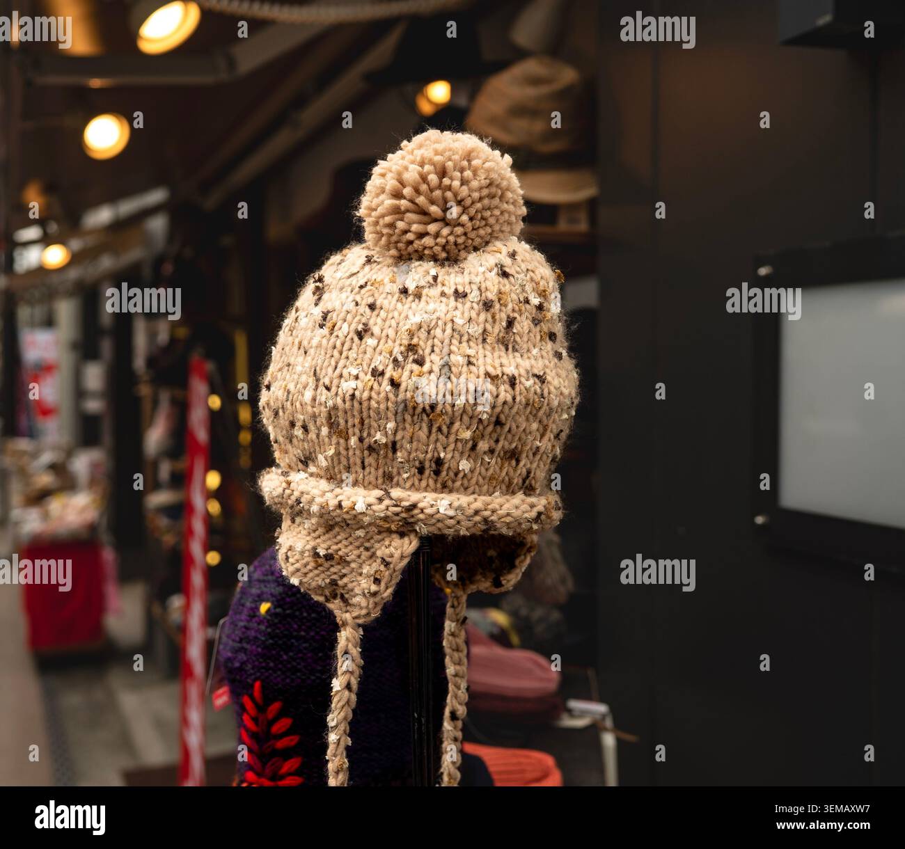 Bonnet d'hiver à rabat en maille confortable avec pompon exposé dans un Street Market Shop Banque D'Images