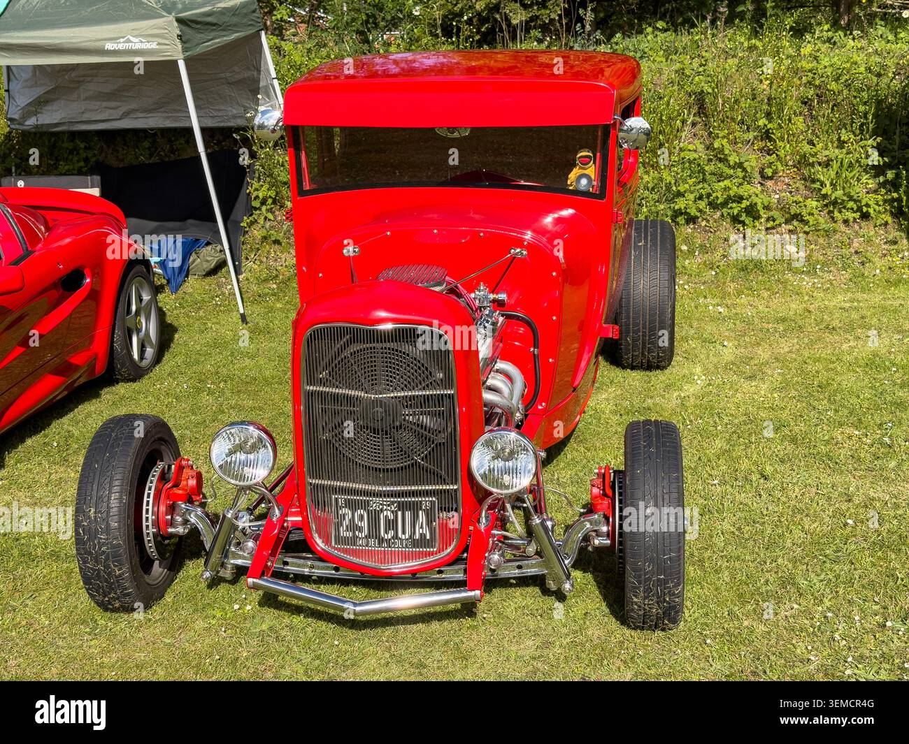 Red 1929 Ford Model A Coupe hot Rod garé sur l'herbe verte lors d'une exposition de voitures en plein air Banque D'Images
