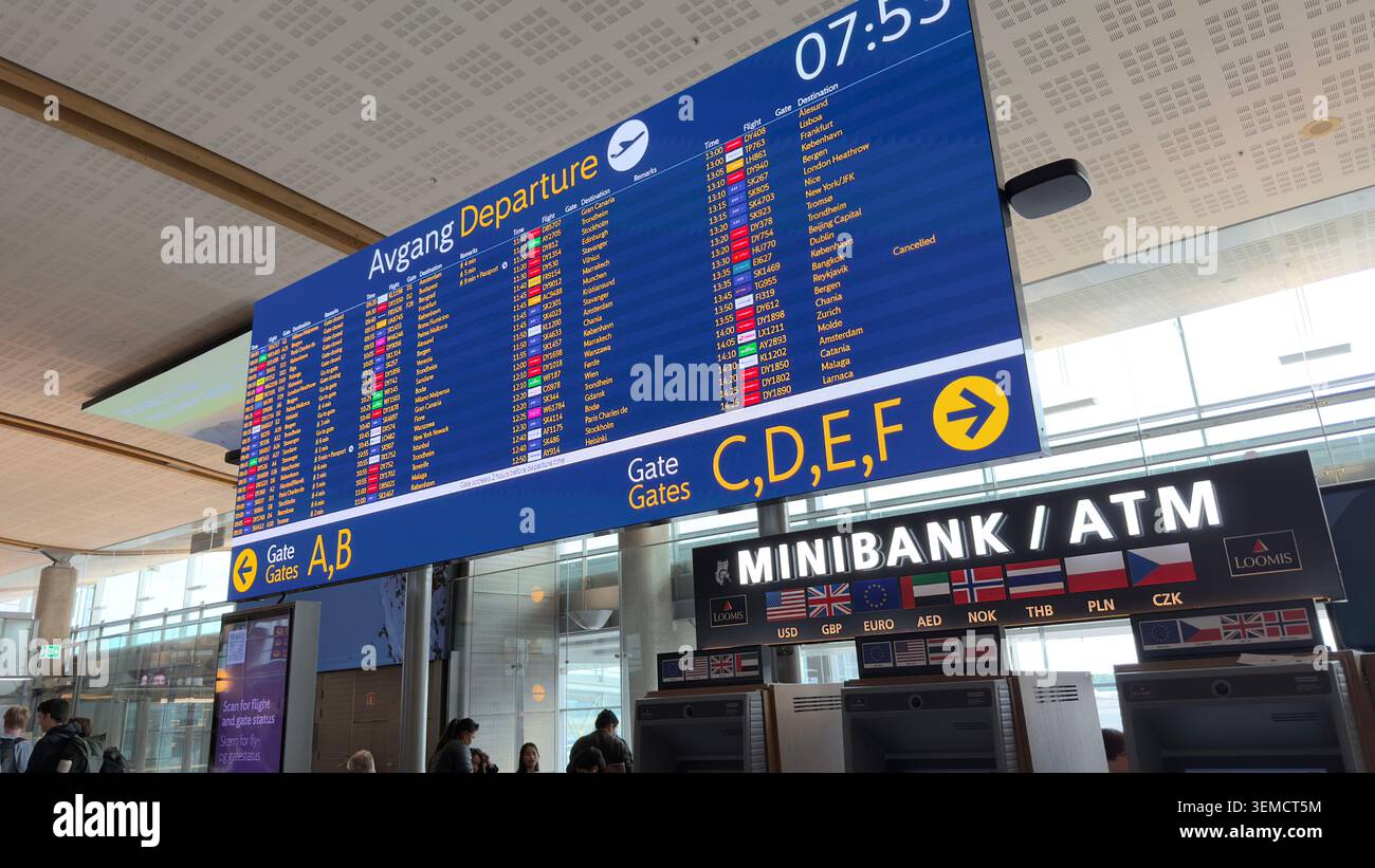 Grand panneau de départ affichant les horaires des vols au-dessus d'un ATM à l'aéroport d'Oslo, Gardermoen, Norvège - Image de stock capturée avec un smartphone