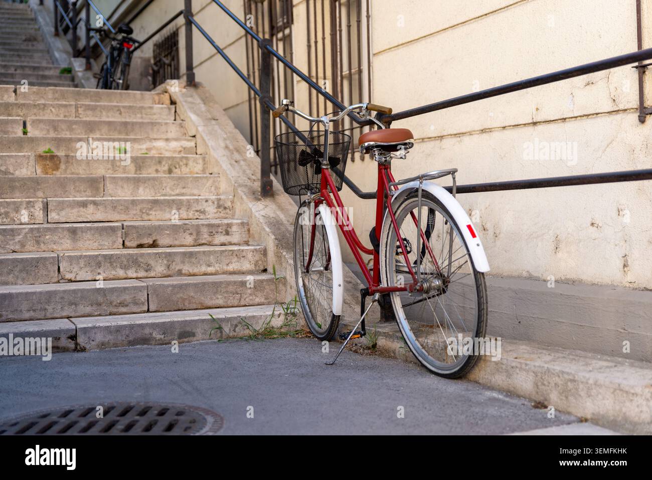 Budapest, Hongrie – 2 mai 2026 : vélo garé à côté des escaliers en pierre historiques dans un quartier résidentiel de Budapest Banque D'Images