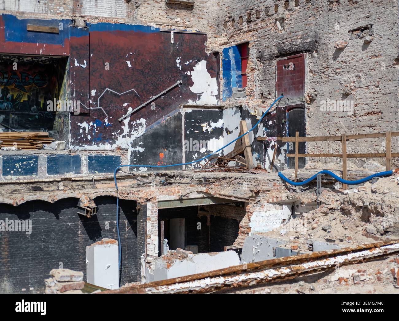 La structure urbaine démolie révèle des murs intérieurs, des gravats et des fondations en béton à la lumière du soleil. Banque D'Images