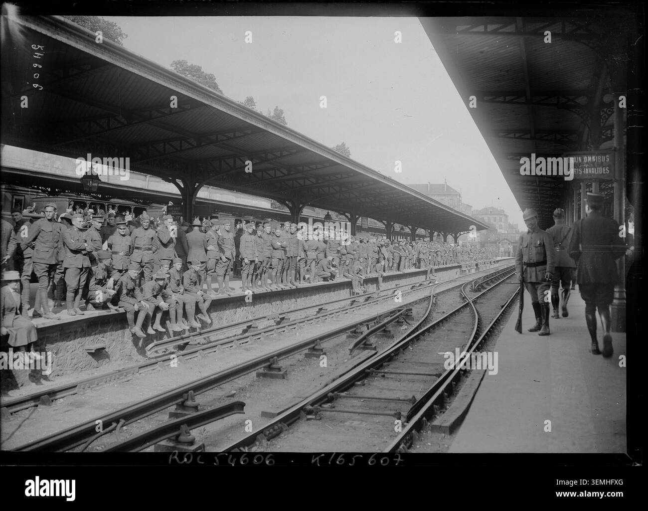 Des militaires attendent un train dans une gare de la région parisienne dans cette photographie de presse de 1919 distribuée par l'Agence Rol, qui enregistre l'activité de transport d'après-guerre et le mouvement des militaires en France. Banque D'Images