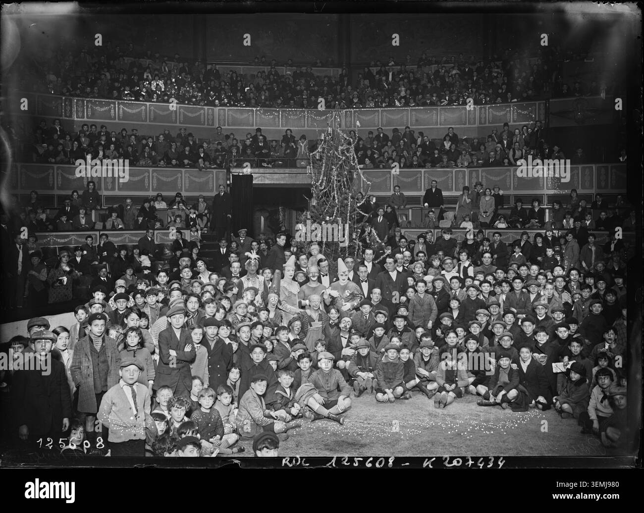 Les écoliers assistent à une célébration du sapin de Noël au cirque d'hiver de Paris le 27 décembre 1927. La photographie de presse enregistre un rassemblement de vacances organisé pour les enfants dans le 11ème arrondissement, reflétant les festivités saisonnières, les fêtes d'enfants et les divertissements publics. Banque D'Images