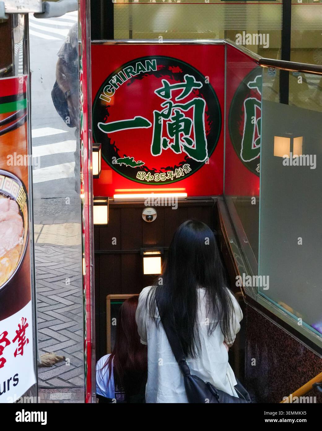Tokyo, Japon – 30 août 2025 : des clients descendent les escaliers sous un panneau Ichiran illuminé dans un restaurant de ramen à Shibuya. Banque D'Images