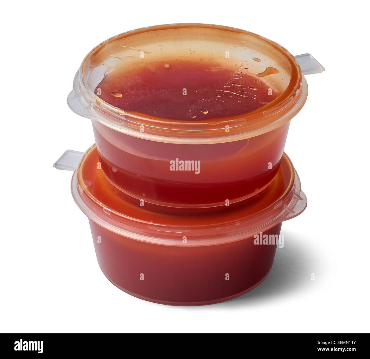 petits récipients empilés de sauce tomate rouge en plastique transparent à fond blanc isolé, emballage transparent jetable de tasse de portion servir avec la pizza Banque D'Images