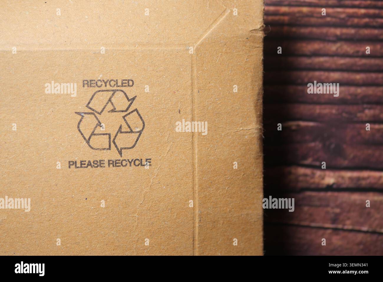 Symbole de recyclage sur la boîte en carton près de la surface en bois Banque D'Images