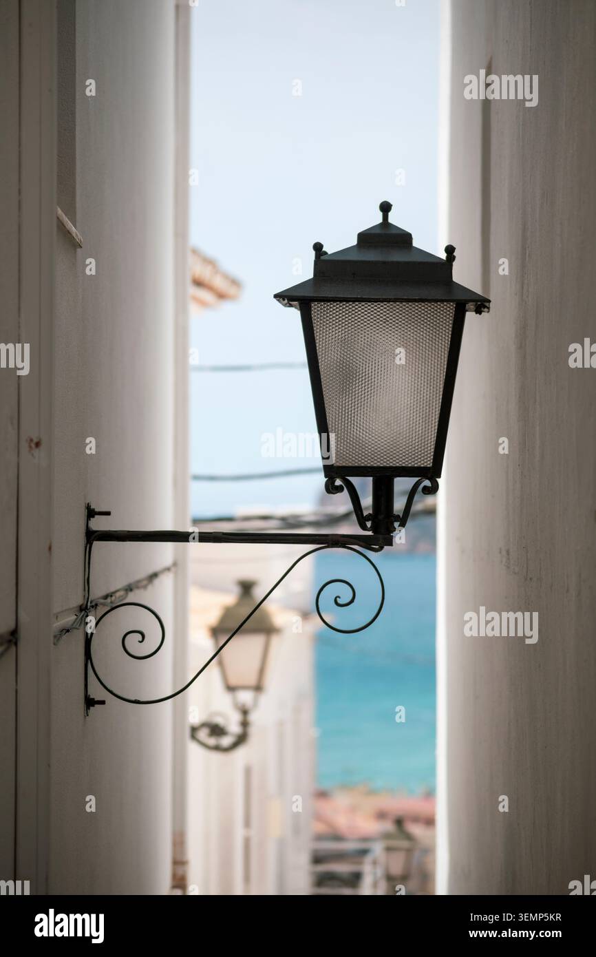 Lampadaire dans une ruelle étroite dans le vieux quartier d'Altea, Alicante, Communauté valencienne, Espagne, avec la mer en arrière-plan Banque D'Images