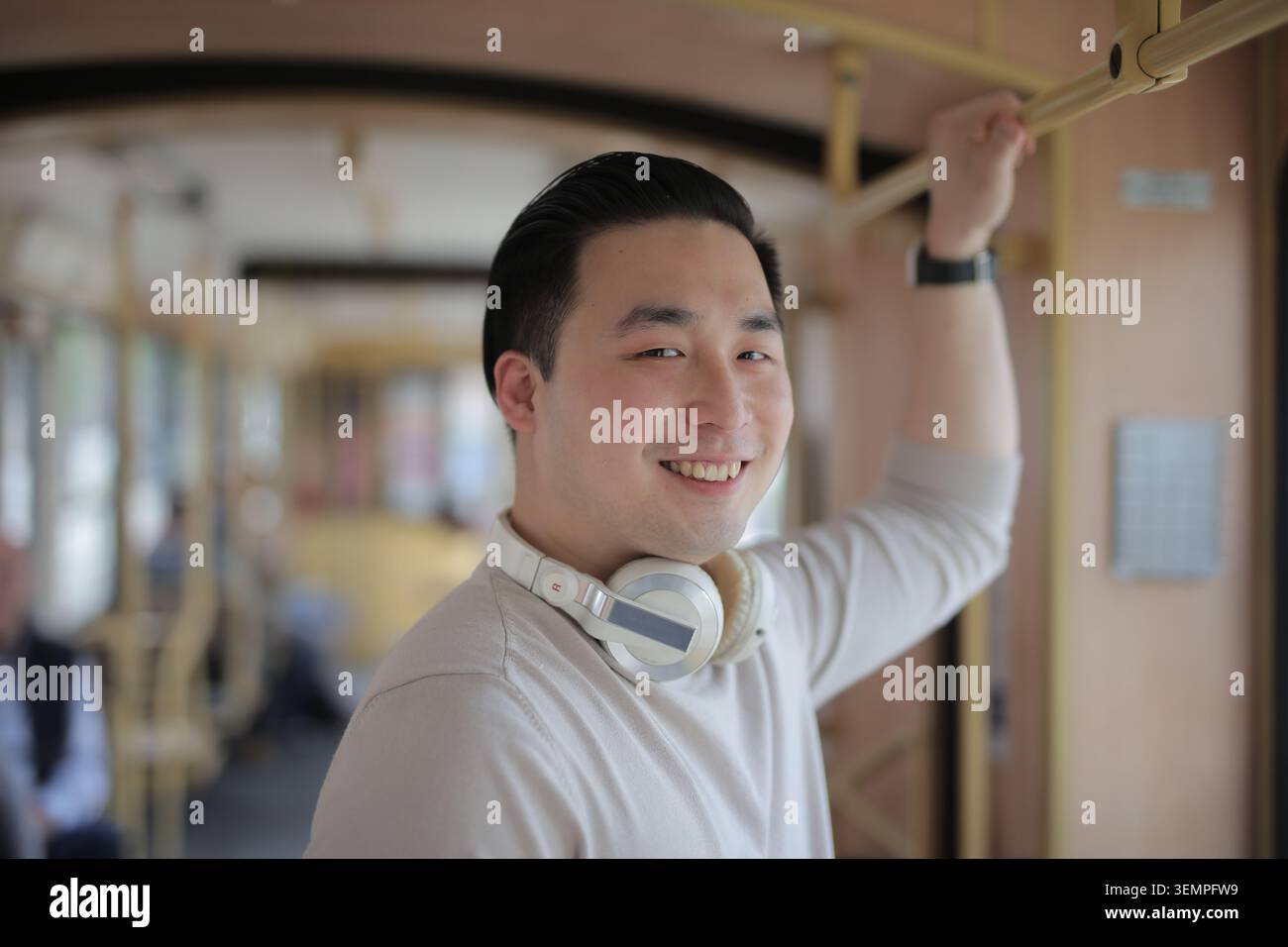 Heureux jeune homme asiatique dans les transports en commun Banque D'Images
