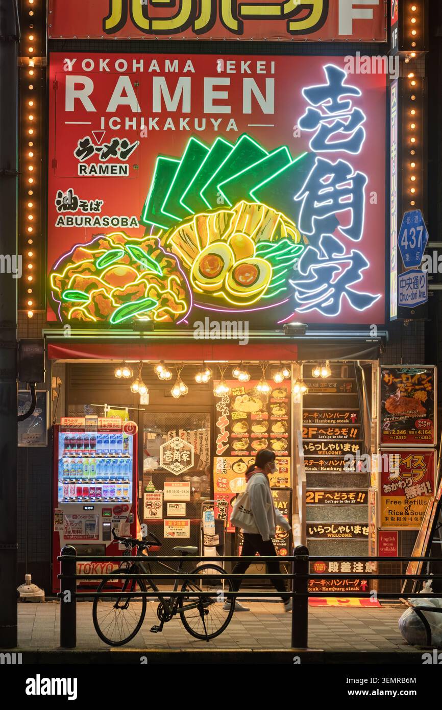 Vue au niveau de la rue d'un panneau lumineux de restaurant ramen avec texte typographique kanji audacieux la nuit, Tokyo, Japon Banque D'Images