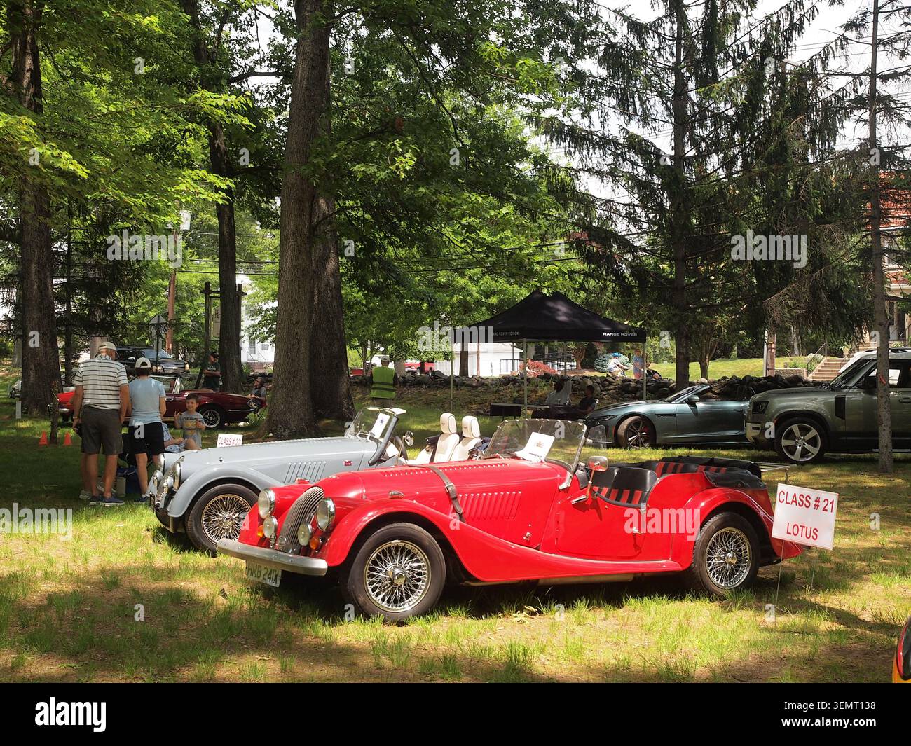 Deux voitures de sport Morgan exposées lors d'un salon automobile britannique du New Jersey. L'un rouge, l'autre gris. Des arbres entourent le lieu. Banque D'Images
