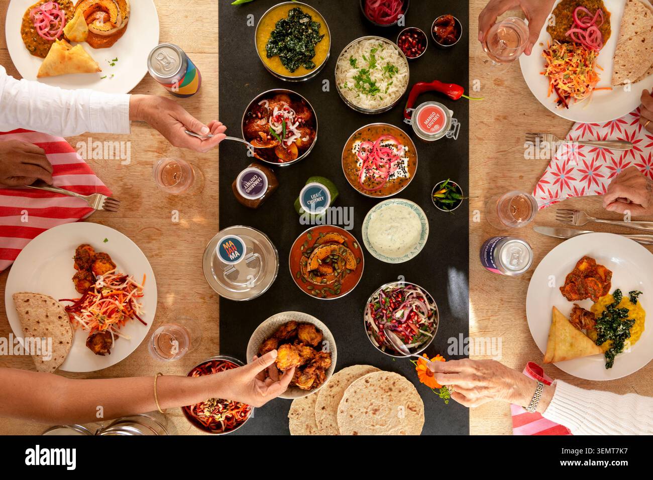Festin indien animé avec des plats variés partagés entre amis dans un cadre de table confortable Banque D'Images