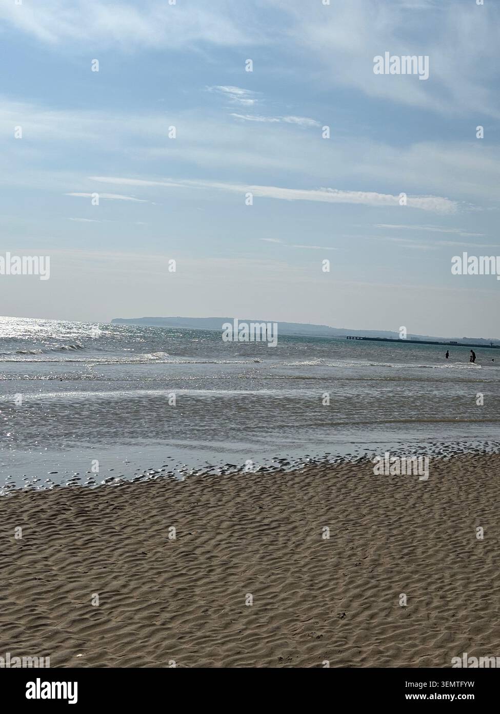Vue sur le rivage à Camber Sands près de Rye, East Sussex, Angleterre, avec des vagues peu profondes, une plage de sable et une côte lointaine. Banque D'Images