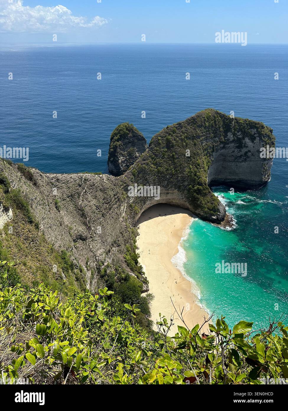 Kelingking Beach s’étire sous sa célèbre falaise T-Rex, où les vagues turquoise rencontrent le sable blanc de Nusa Penida - Image de stock capturée avec un smartphone