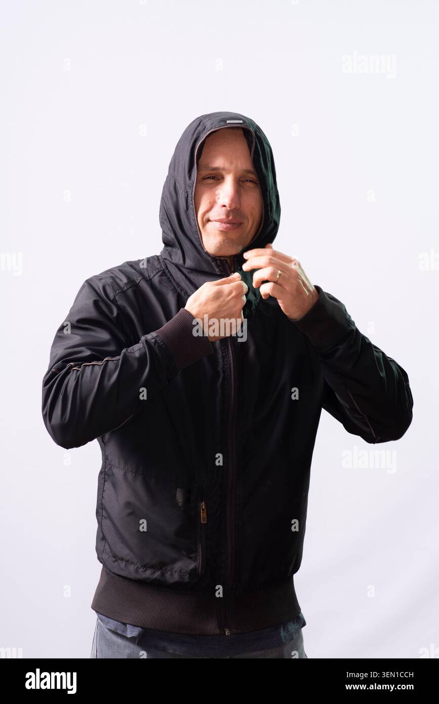 Markus Zusak est dans un studio portant un sweat à capuche noir. Il a un sourire détendu sur le visage. Le fond est clair, se concentrant sur ses actions et expres Banque D'Images