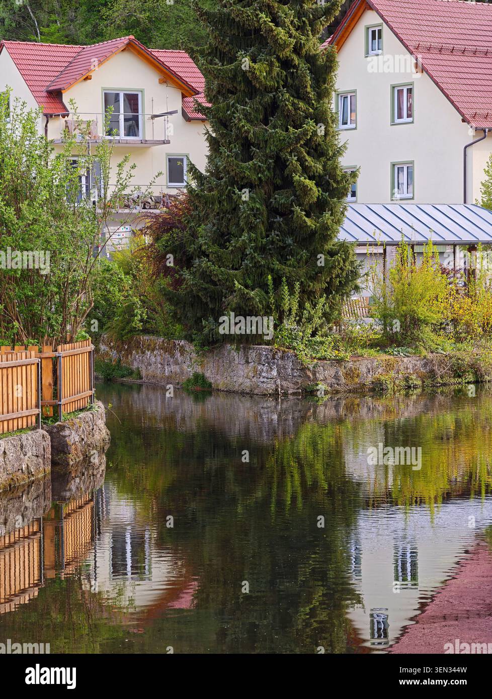 Bâtiments résidentiels le long de la rivière Püttlach avec des reflets d'eau, Pottenstein, haute-Franconie, Franconie, Bavière, Allemagne, Suisse franconienne Banque D'Images