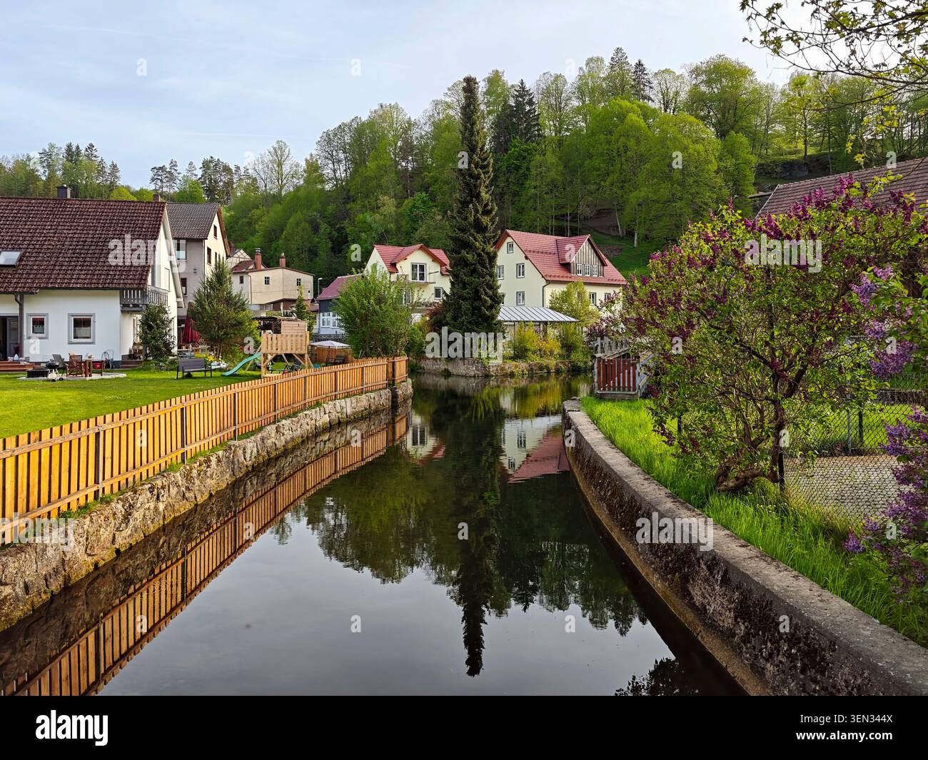 Bâtiments résidentiels le long de la rivière Püttlach avec des reflets d'eau, Pottenstein, haute-Franconie, Franconie, Bavière, Allemagne, Suisse franconienne Banque D'Images