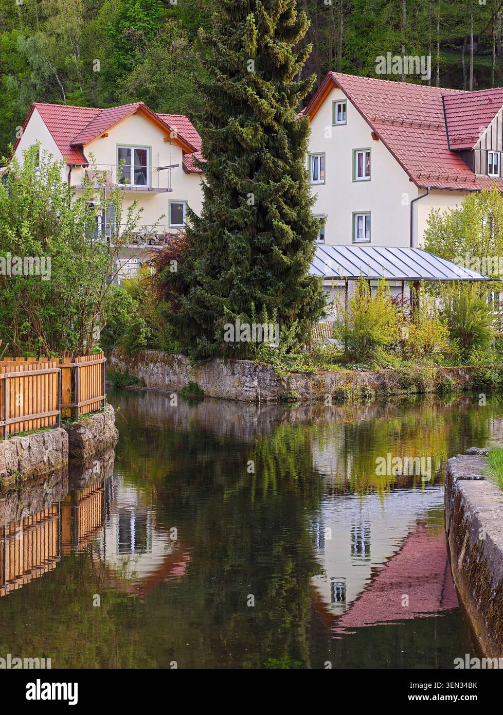 Bâtiments résidentiels le long de la rivière Püttlach avec des reflets d'eau, Pottenstein, haute-Franconie, Franconie, Bavière, Allemagne, Suisse franconienne Banque D'Images