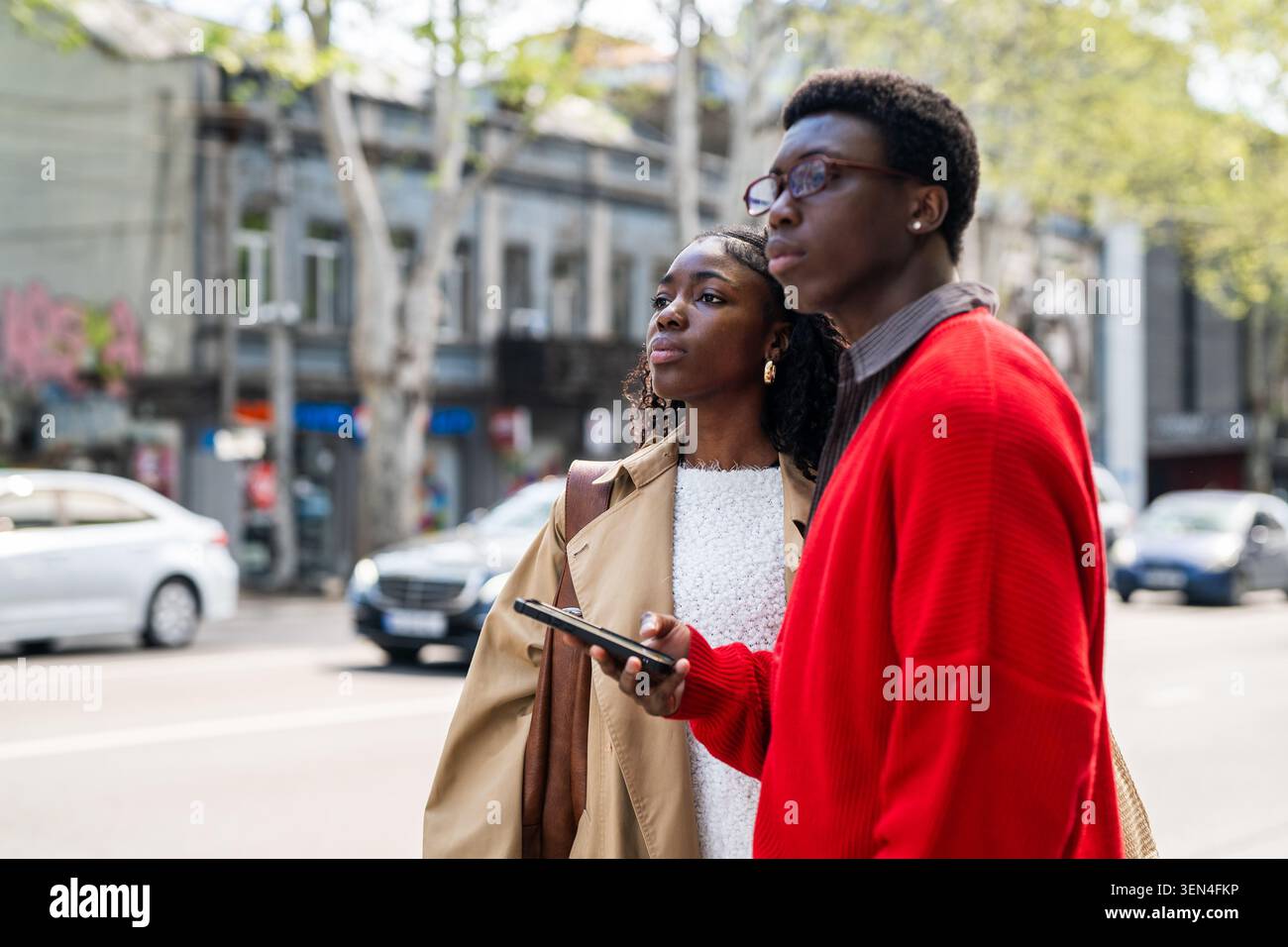 Les touristes afro-américains concentrés attendent un taxi tout en se tenant dans la rue. Banque D'Images