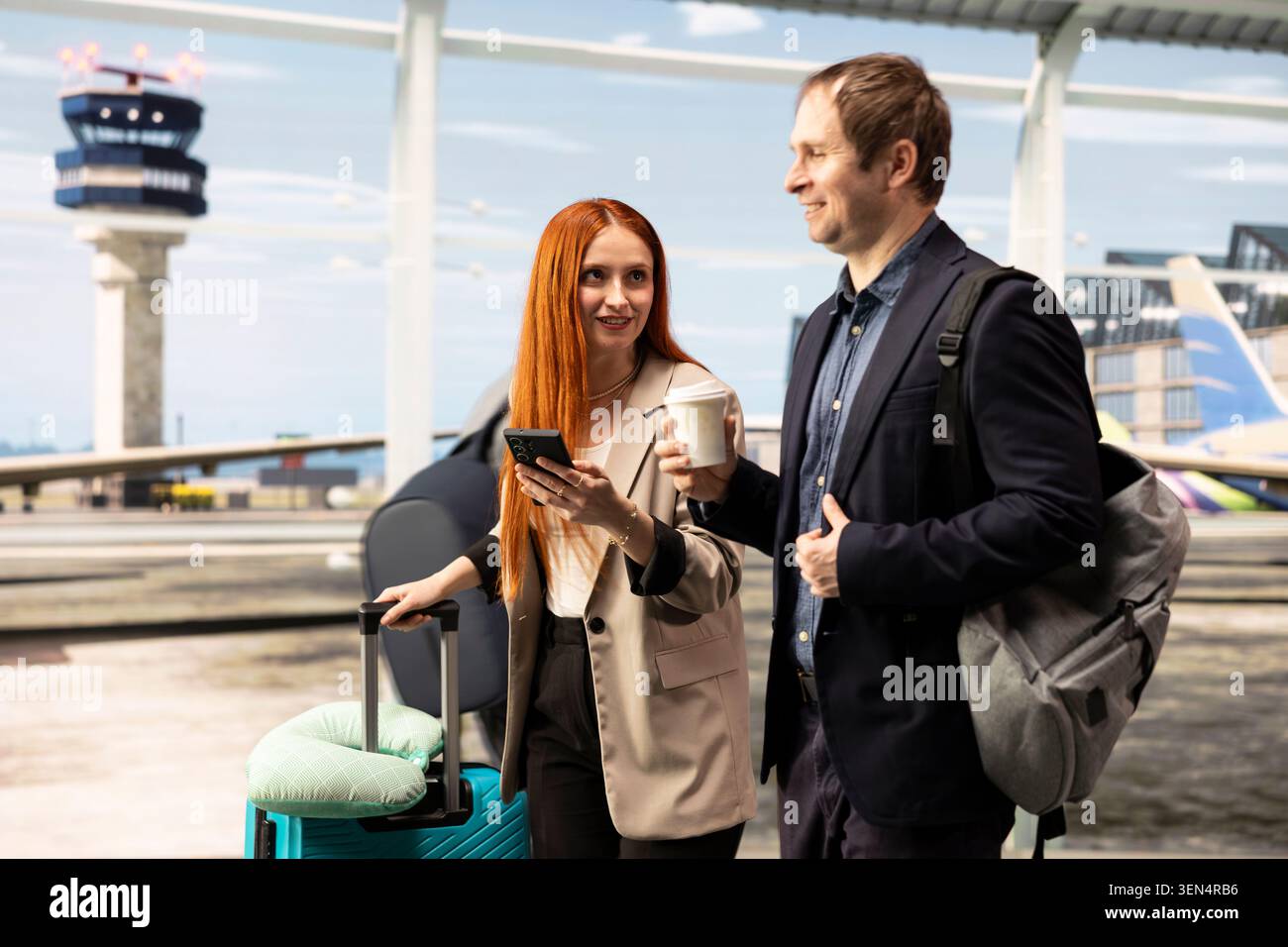 Homme et femme souriant discutant dans l'aéroport, tenant une tasse de café, smartphone et bagages. Voyageurs d'affaires heureux transportant des bagages dans le terminal moderne de l'aéroport, parlant et utilisant le téléphone mobile Banque D'Images
