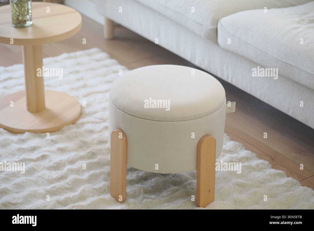 Petit tabouret rond dans un salon avec un tapis léger Banque D'Images