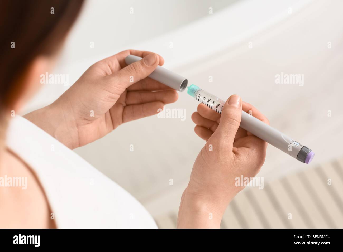 Femme assemblant stylo à insuline pour le traitement du diabète, dispositif médical pour l'auto-injection, les soins de santé et la gestion des maladies chroniques Banque D'Images