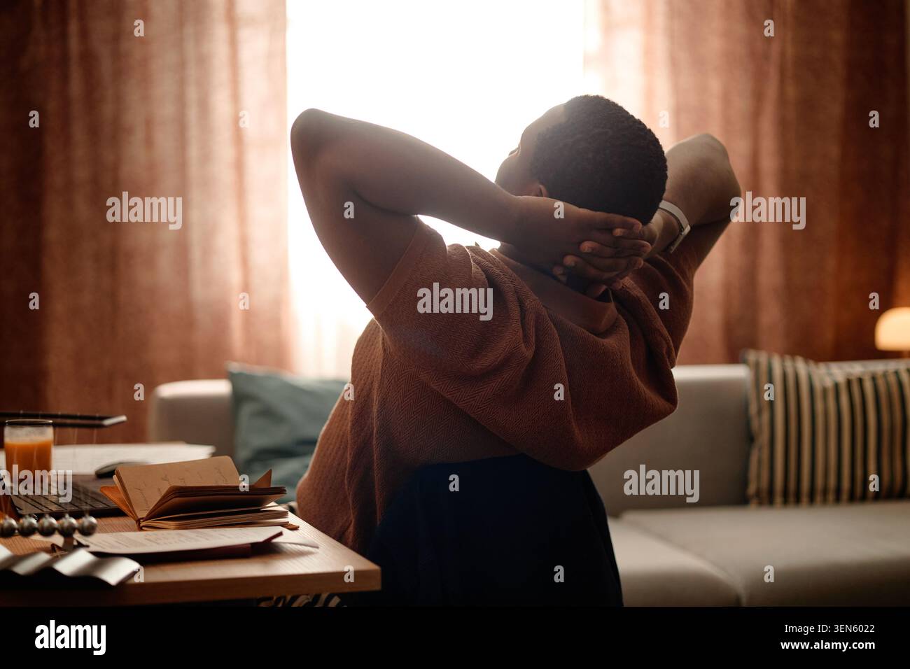 Homme noir s'étirant à la maison après Screen Time Burnout Banque D'Images