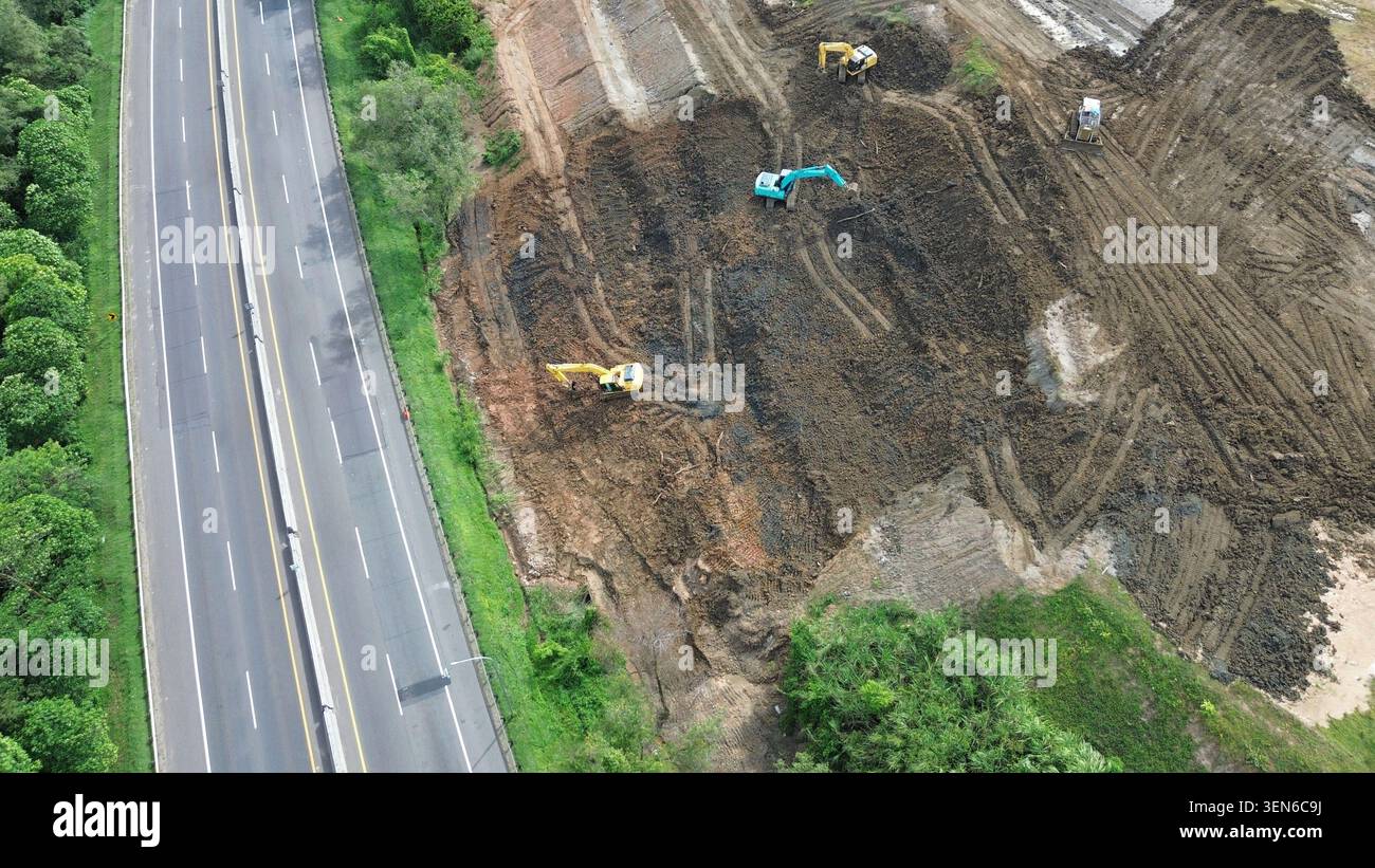 Une vue aérienne de haut en bas des travaux de terrassement et d'excavation pour un nouveau projet de construction d'autoroute, mettant en vedette plusieurs excavatrices en Indonésie. Banque D'Images