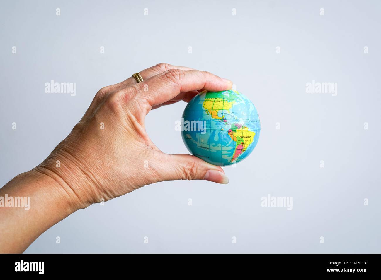 Main tenant un petit globe. Sur fond blanc. Banque D'Images