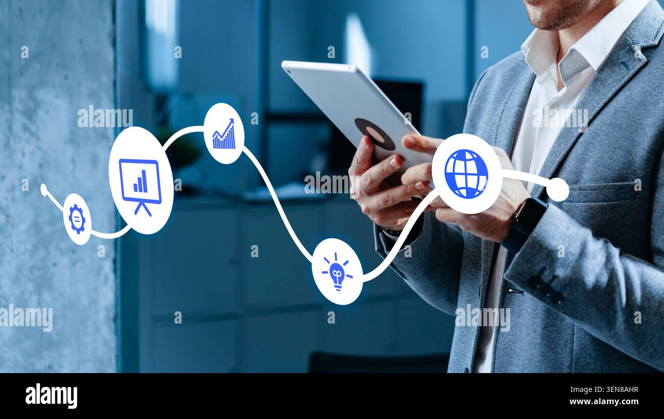 Professionnel utilisant la tablette pour gérer le contenu en ligne dans un environnement de bureau occupé Banque D'Images