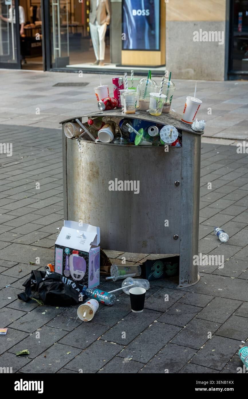Poubelle débordante ou poubelle dans le centre-ville de Cardiff avec des canettes et des bouteilles qui se renversent dans la rue pendant une période de chaleur. Banque D'Images