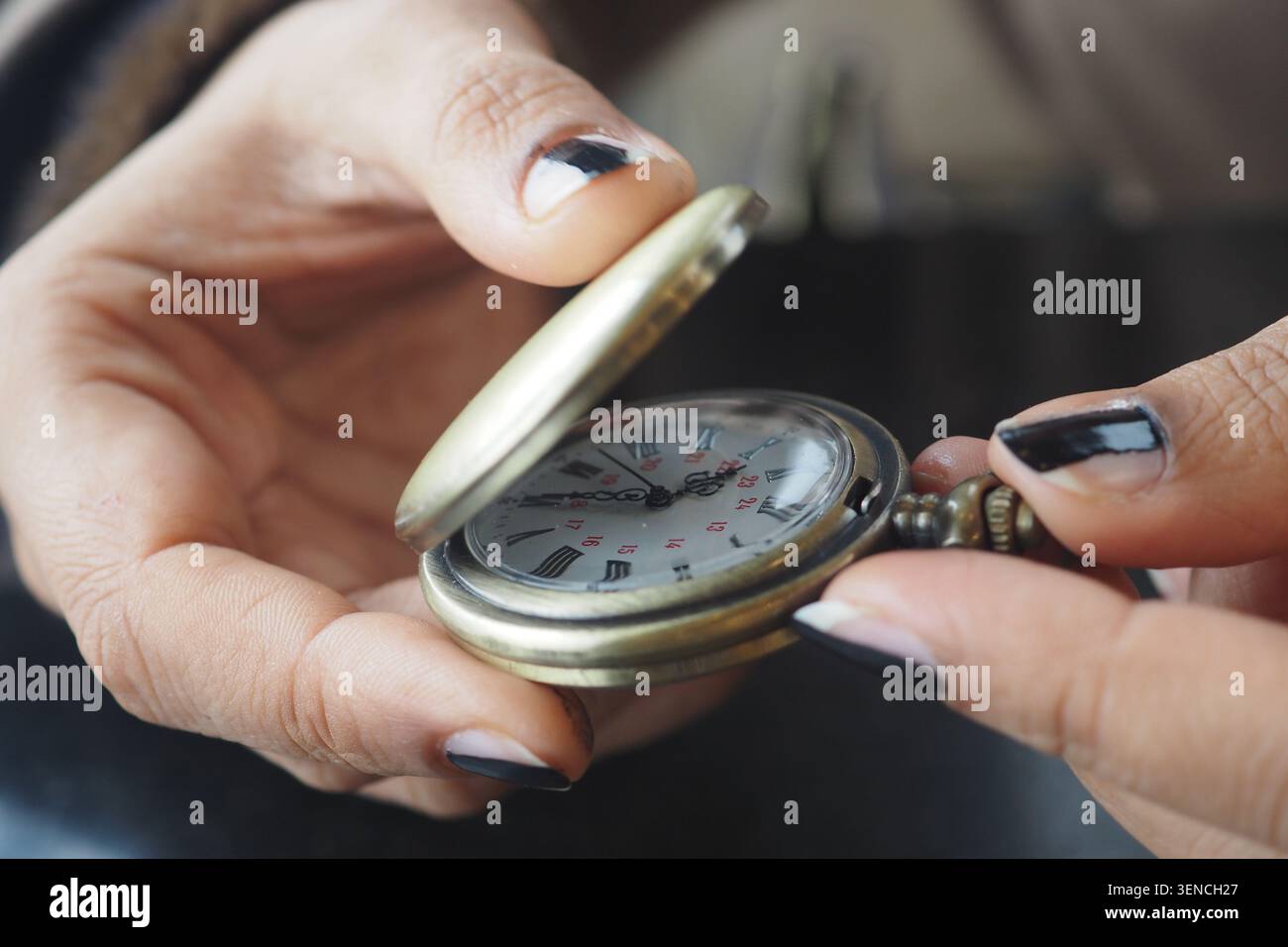 Mains tenant une montre de poche vintage dans une vue rapprochée Banque D'Images