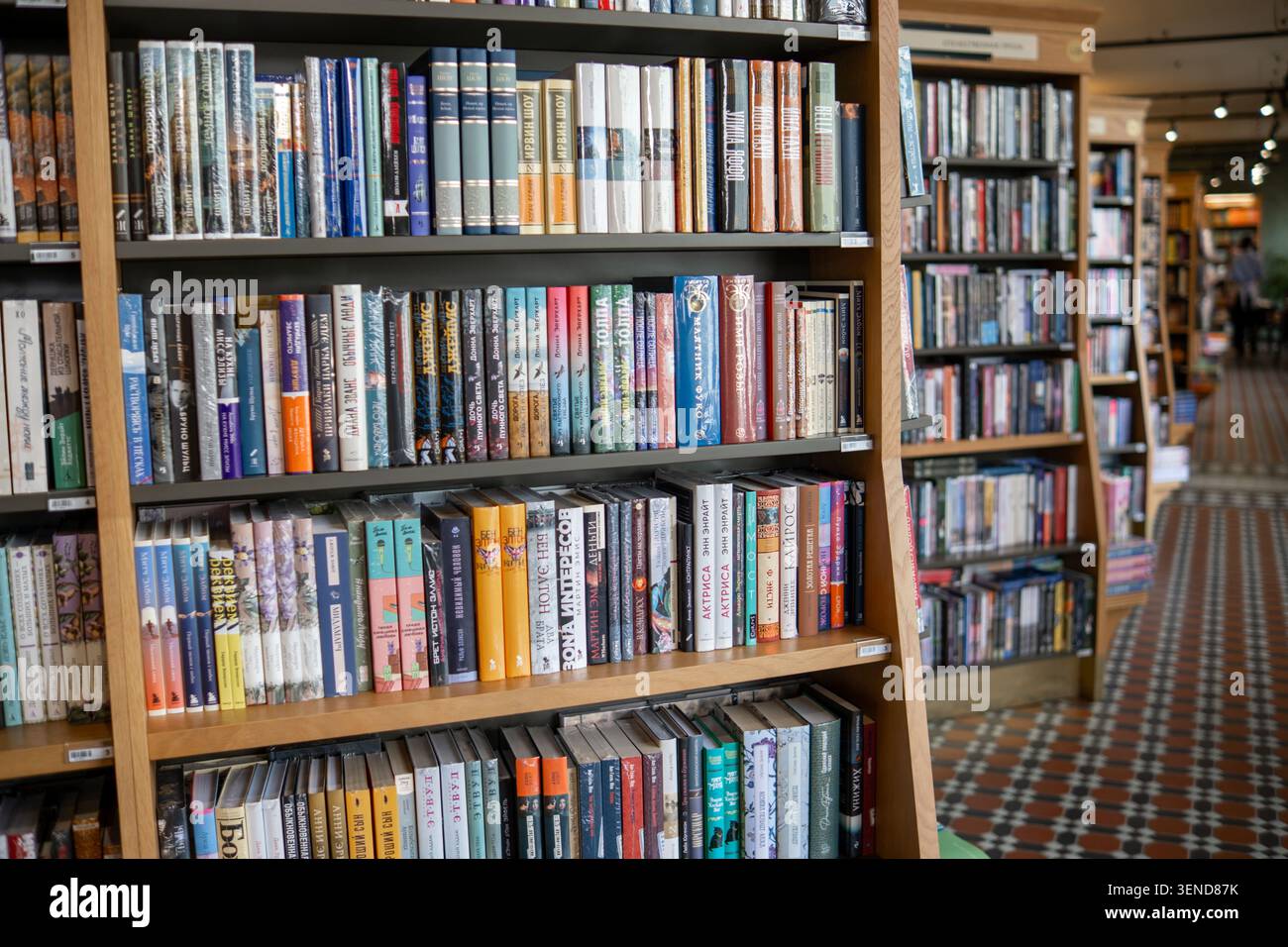 Saint-Pétersbourg, Russie - 27 avril 2026 : étagères remplies de divers genres de livres dans une librairie confortable avec des carreaux de sol à motifs Banque D'Images