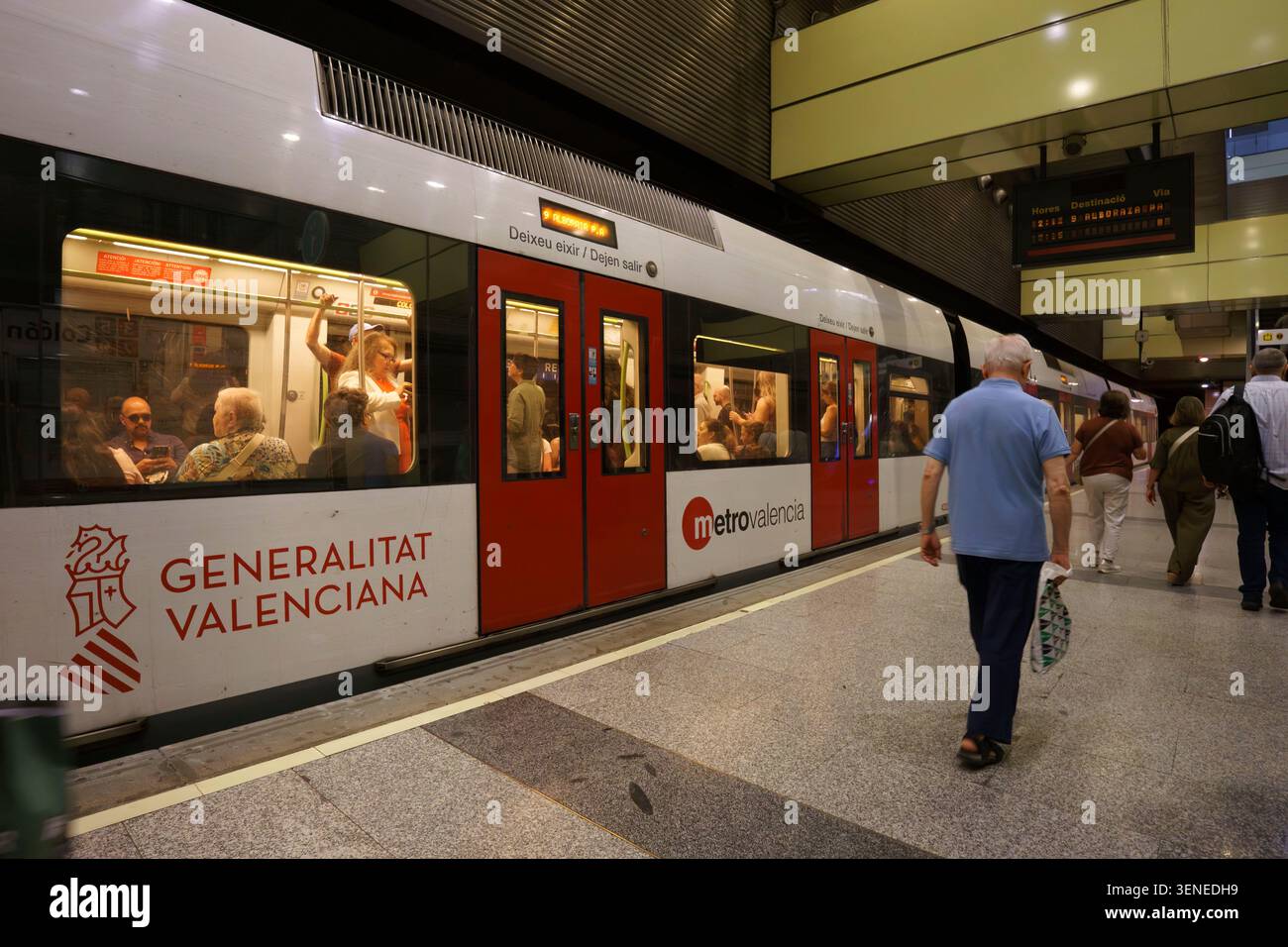 Un train de métro Metrovalencia s'est arrêté à une gare de Valence, en Espagne, avec des passagers qui attendaient sur le quai Banque D'Images