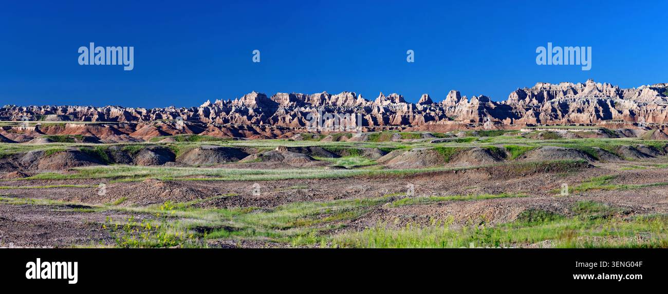 Une large vue panoramique sur les formations géologiques spectaculaires et le paysage érodé du parc national des Badlands sous un ciel bleu clair Banque D'Images
