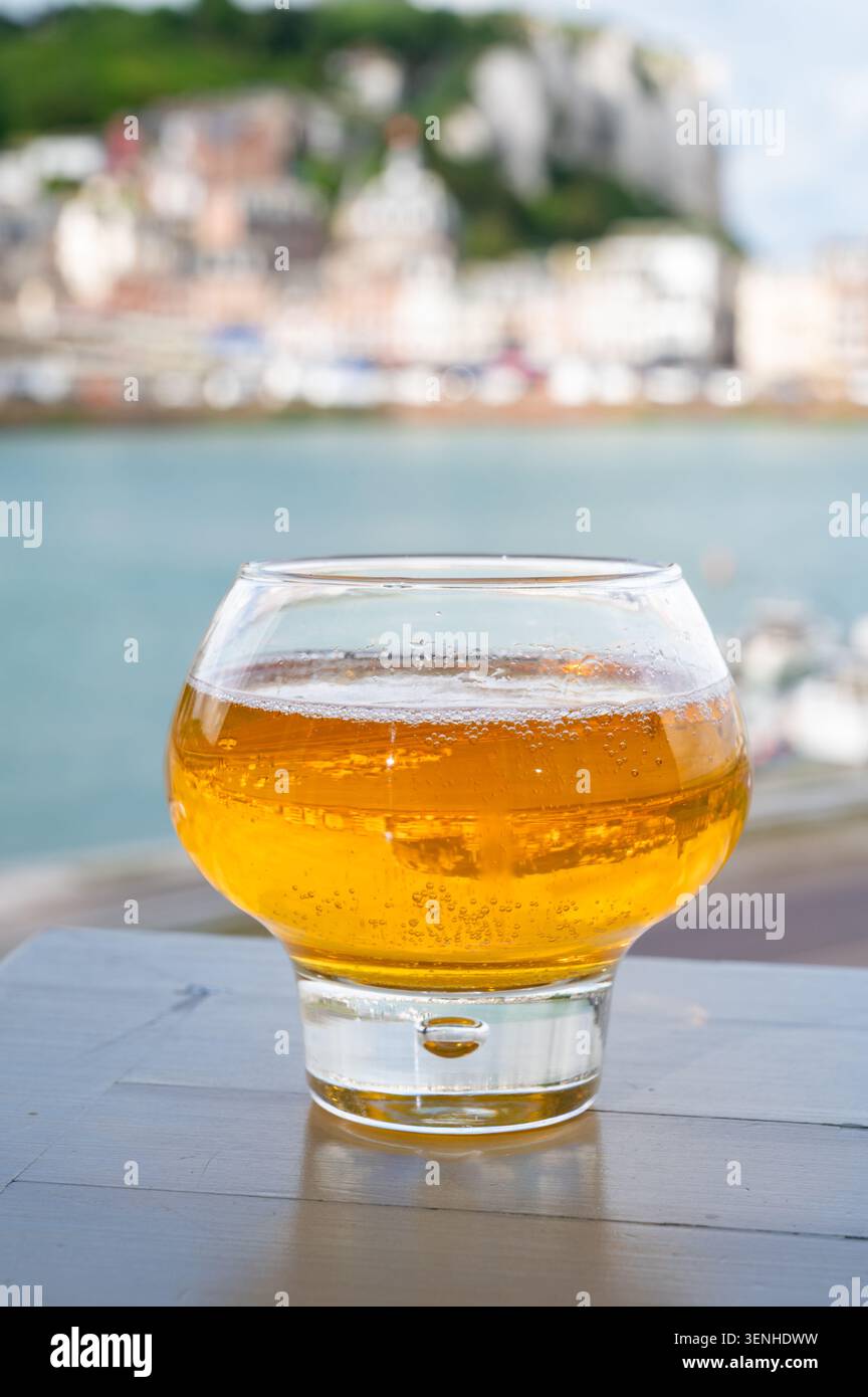 Cidre de pomme de Normandie versé avec vue sur le Tréport avec de superbes falaises de craie dorées, boisson pétillante aux pommes, goût rafraîchissant. Sur fond pictu Banque D'Images