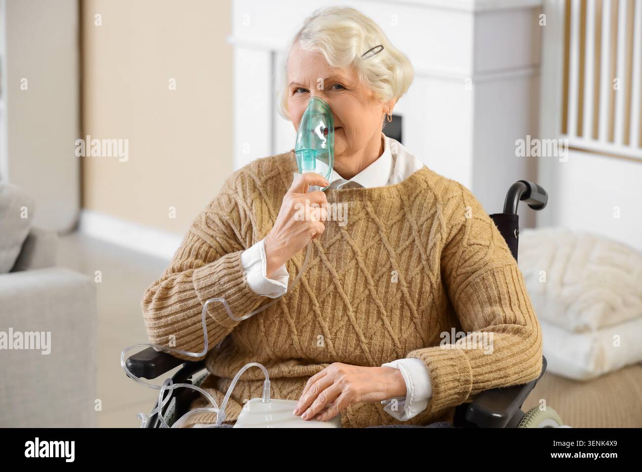 Femme âgée en fauteuil roulant utilisant le nébuliseur à la maison Banque D'Images
