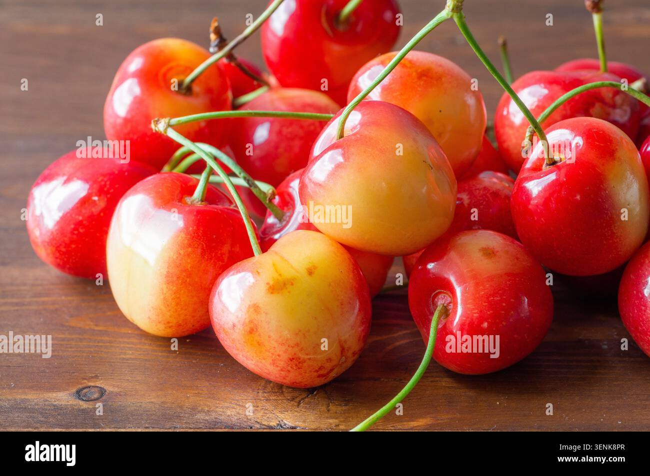 Les cerises douces mûres reposent sur un fond en bois. Banque D'Images