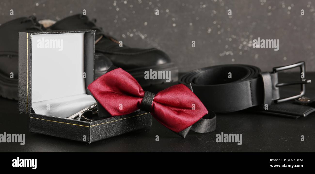Noeud papillon rouge élégant dans une boîte cadeau avec accessoires formels pour hommes, chaussures noires et ceinture en cuir pour les occasions spéciales Banque D'Images
