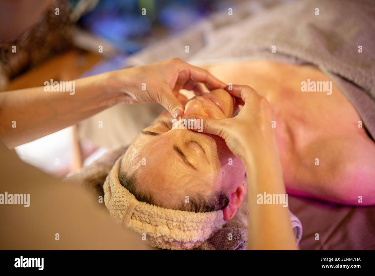 Séance de massage en clinique cosmétique, femme reposant sur un lit spa et subissant un traitement de soins de la peau. Banque D'Images