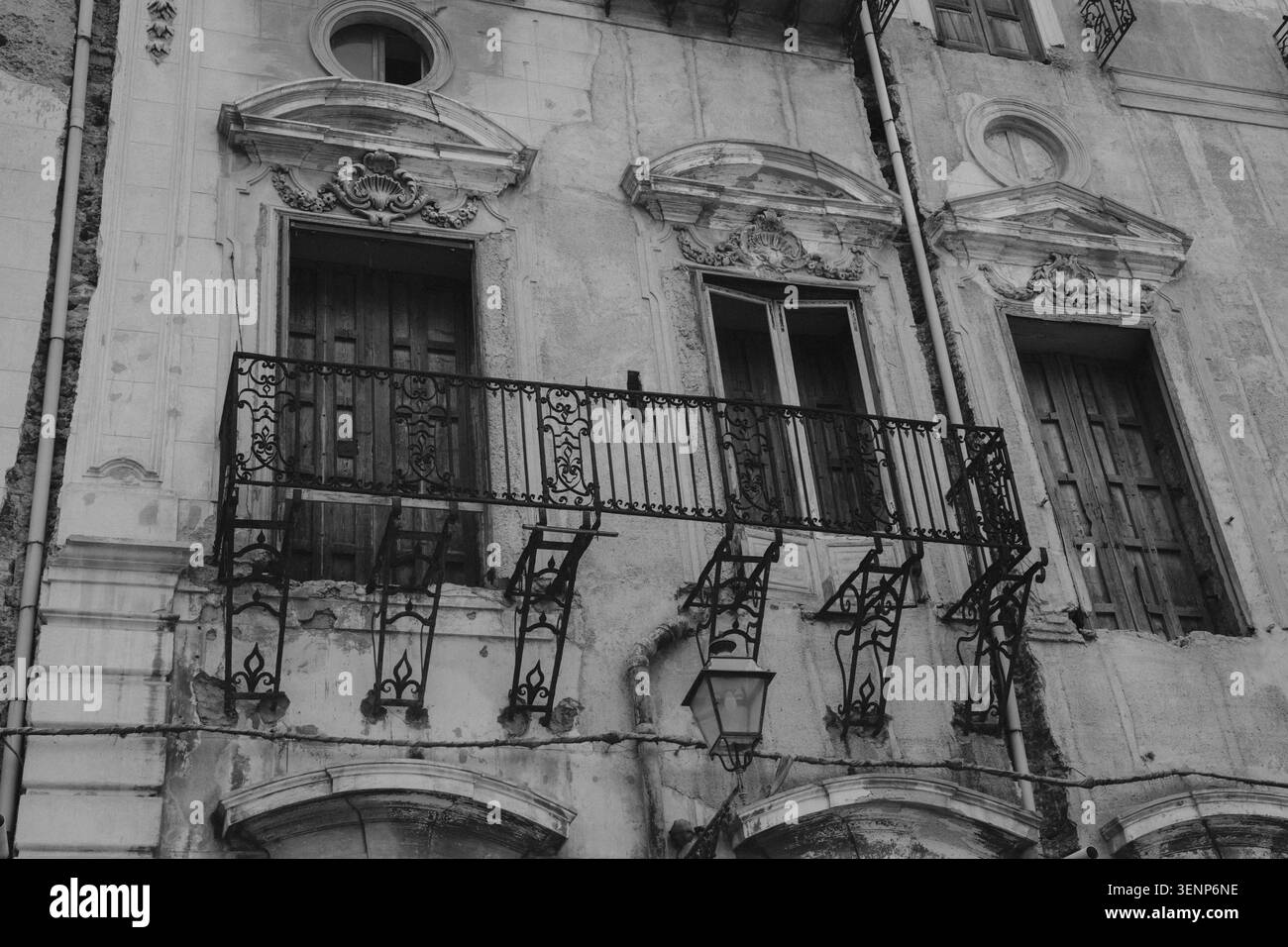 Façade baroque altérée avec balcons en fer forgé et plâtre pelable en noir et blanc dans la vieille ville de Sicile Italie. Photo de haute qualité Banque D'Images